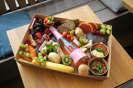 Box mit verschiedenen Gerichten und Weinflasche